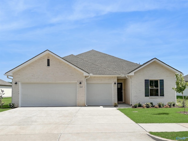 single story home featuring roof with shingles, brick siding, a garage, a front yard, and concrete driveway