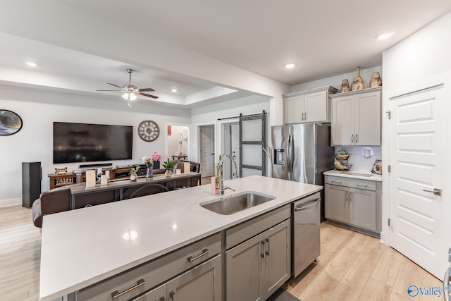 kitchen featuring a sink, appliances with stainless steel finishes, gray cabinets, and open floor plan