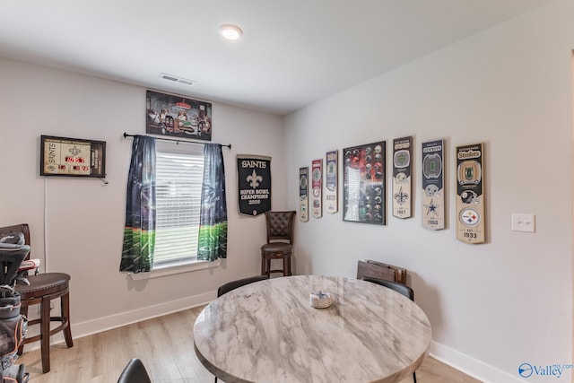 dining area featuring baseboards, visible vents, and light wood-style flooring