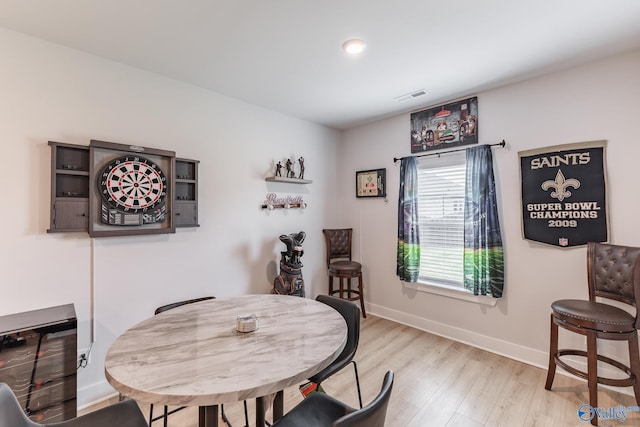 dining space featuring baseboards, light wood finished floors, and visible vents