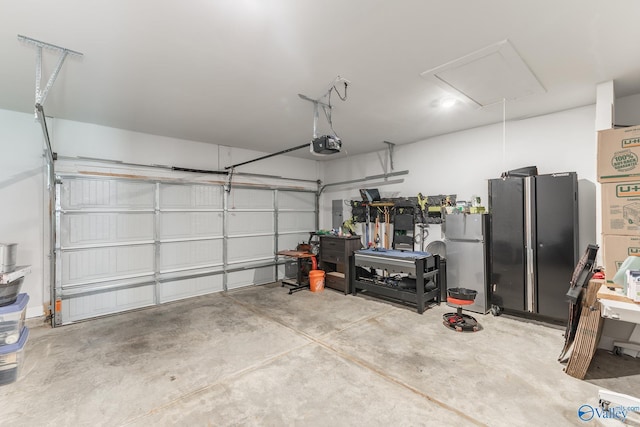 garage with a garage door opener and freestanding refrigerator
