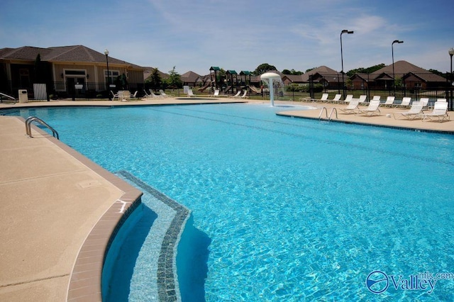pool with a patio area and fence
