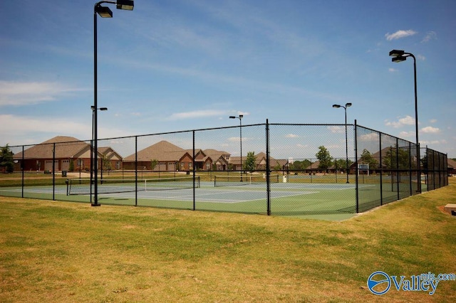 view of sport court featuring a yard and fence