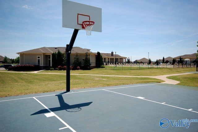 view of basketball court featuring a lawn, fence, and community basketball court