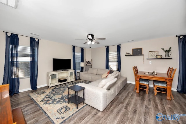 living area featuring ceiling fan, baseboards, a wealth of natural light, and wood finished floors