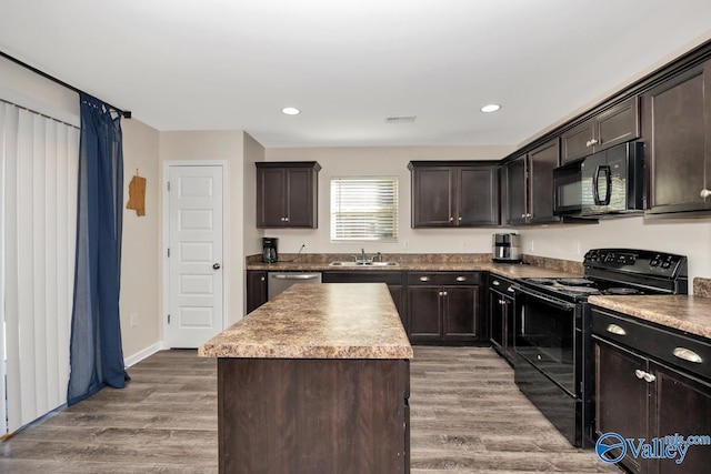 kitchen featuring visible vents, wood finished floors, dark brown cabinets, black appliances, and a sink