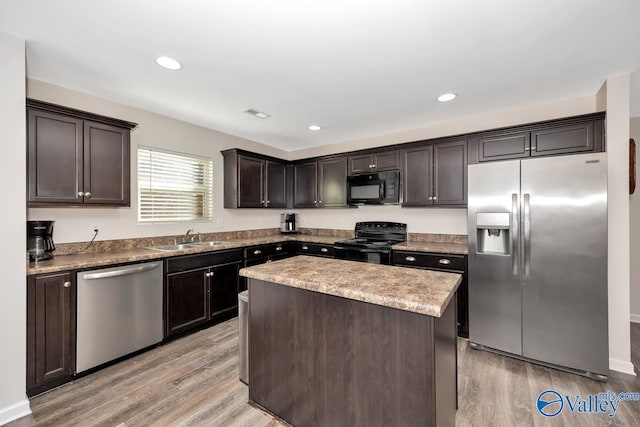 kitchen with black appliances, a sink, light wood-style flooring, and dark brown cabinetry