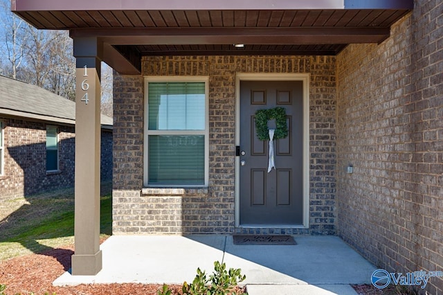 view of exterior entry featuring brick siding