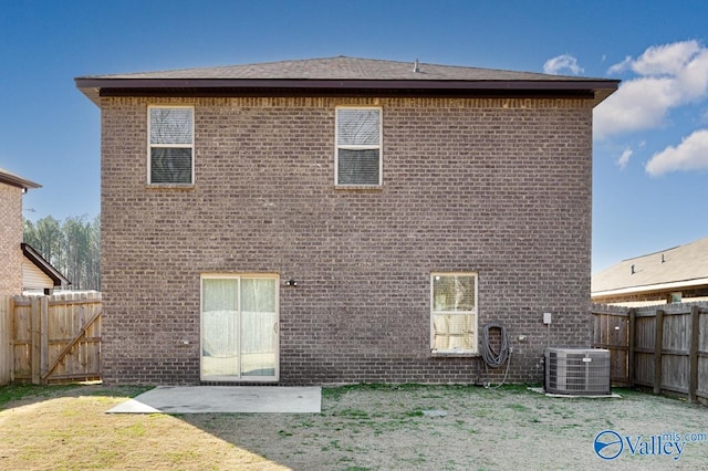 back of house featuring a yard, brick siding, a fenced backyard, and cooling unit