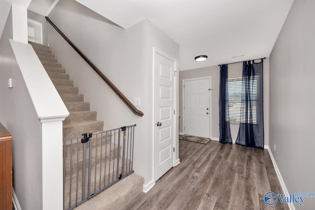 stairs featuring wood finished floors and baseboards