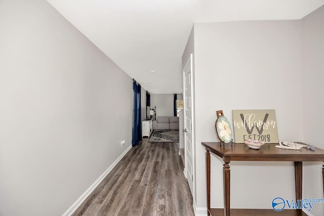 hallway featuring wood finished floors and baseboards