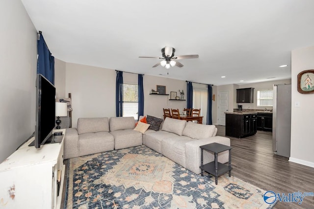 living room featuring a ceiling fan, recessed lighting, baseboards, and wood finished floors