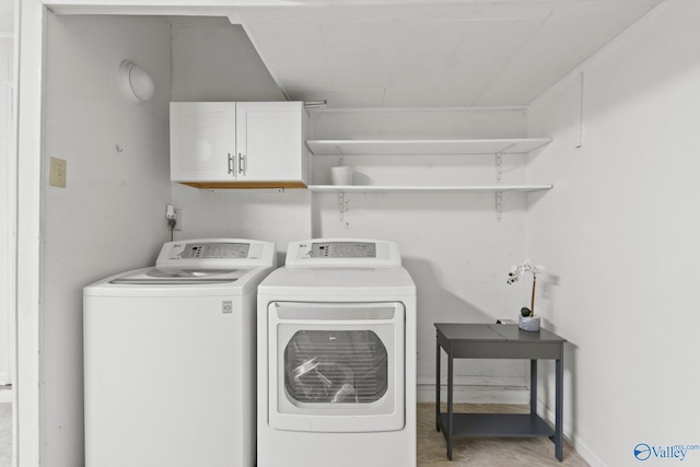 laundry room featuring separate washer and dryer and cabinets