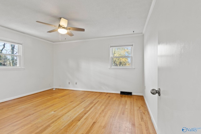 unfurnished room featuring ceiling fan, ornamental molding, a healthy amount of sunlight, and light wood-type flooring