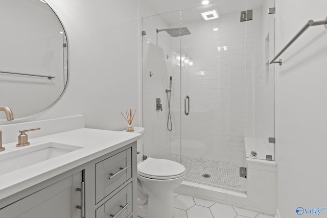 bathroom featuring tile patterned flooring, vanity, toilet, and walk in shower