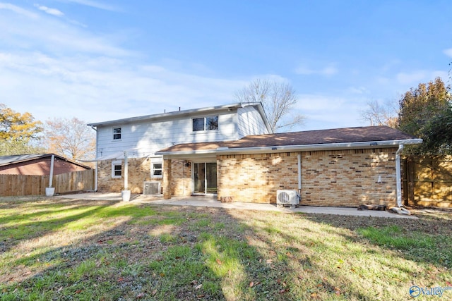 back of house with central AC, a patio area, and a lawn