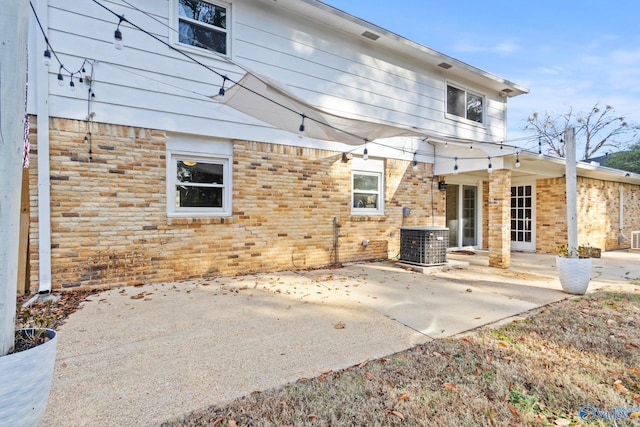 back of property featuring cooling unit and a patio