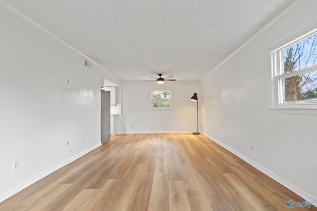 spare room with crown molding, light hardwood / wood-style floors, and ceiling fan