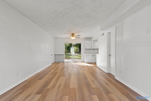 unfurnished living room with a textured ceiling, ceiling fan, and light wood-type flooring