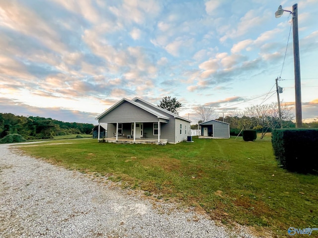 view of front of home with a lawn, a porch, and a storage unit