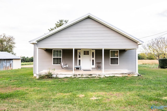 bungalow-style home featuring covered porch and a front yard