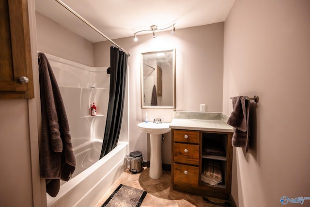 bathroom with tile patterned flooring, shower / bath combination with curtain, and sink