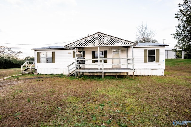 back of house featuring a lawn and a porch