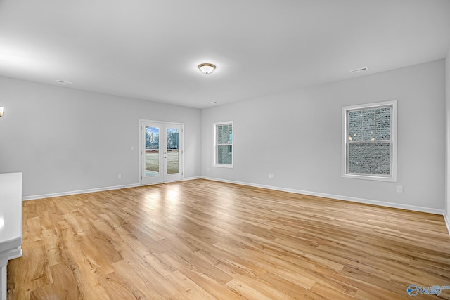 spare room featuring light hardwood / wood-style flooring and french doors