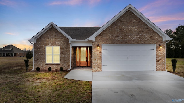 view of front of house with a garage and a yard