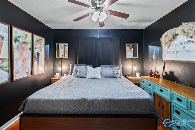 bedroom featuring ceiling fan, hardwood / wood-style floors, and a textured ceiling