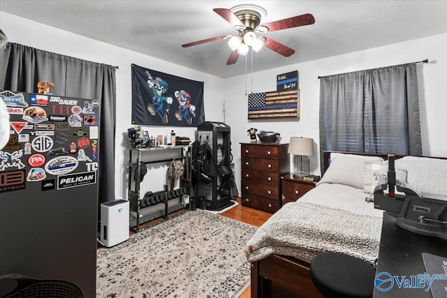 bedroom featuring a textured ceiling, ceiling fan, and hardwood / wood-style flooring