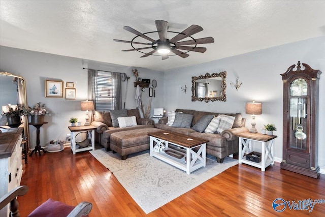 living room with ceiling fan, a textured ceiling, and dark hardwood / wood-style flooring