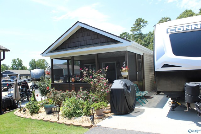 rear view of property featuring a sunroom