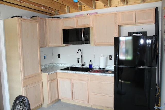 kitchen with black refrigerator, sink, and light brown cabinets