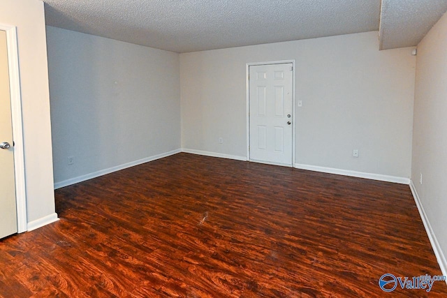 unfurnished room featuring dark hardwood / wood-style floors and a textured ceiling