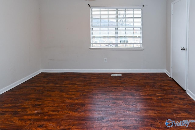 spare room with dark wood-type flooring