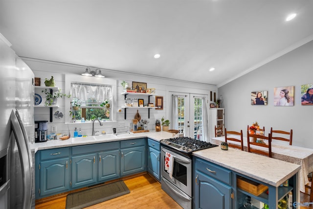 kitchen with blue cabinetry, sink, stainless steel appliances, and light wood-type flooring