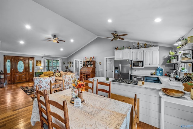 dining area featuring light wood-type flooring, vaulted ceiling, ceiling fan, and ornamental molding