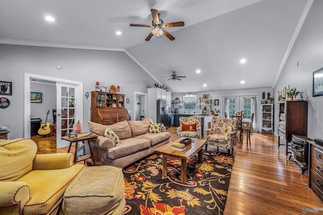 living room with ceiling fan, french doors, crown molding, lofted ceiling, and hardwood / wood-style flooring