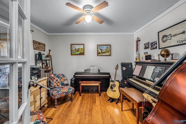 living area with ornamental molding, ceiling fan, and light hardwood / wood-style floors