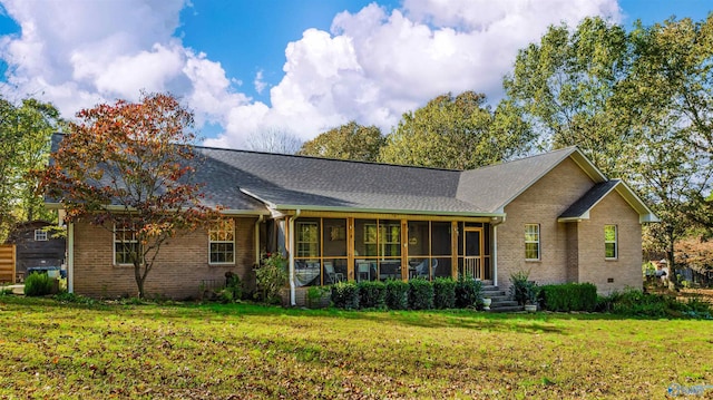 rear view of property featuring a lawn and a sunroom