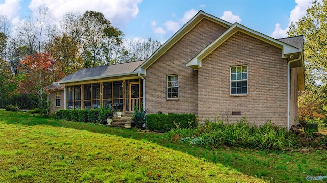 back of property with a lawn and a sunroom