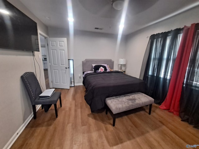 bedroom featuring visible vents, baseboards, and wood finished floors