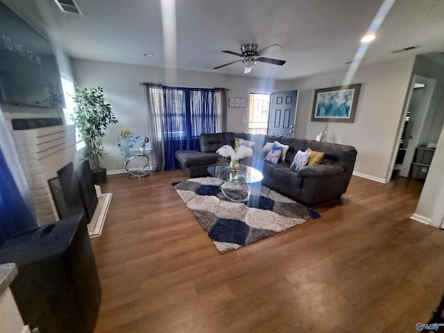 living area featuring a fireplace, visible vents, and wood finished floors