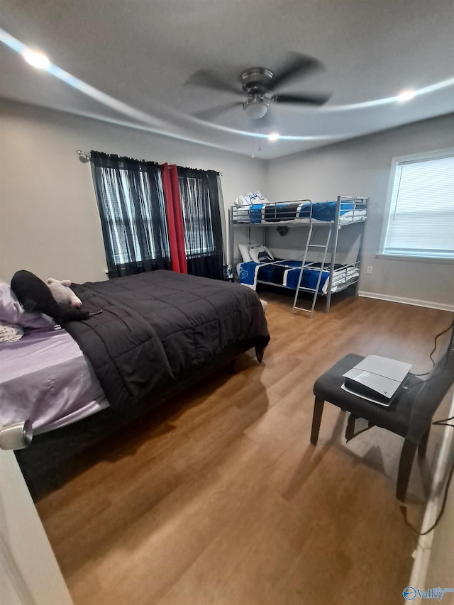 bedroom with ceiling fan, baseboards, and wood finished floors