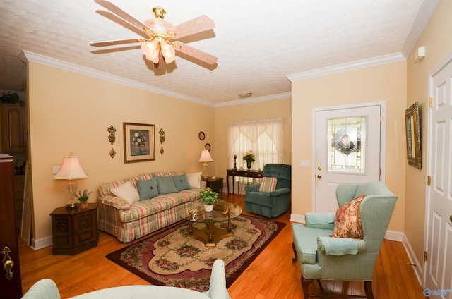 living room featuring ceiling fan, hardwood / wood-style flooring, crown molding, and a textured ceiling