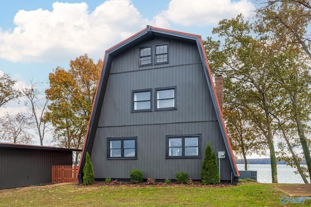 view of side of property with a water view and a lawn