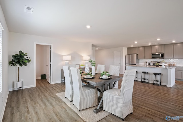 dining area featuring sink and light wood-type flooring