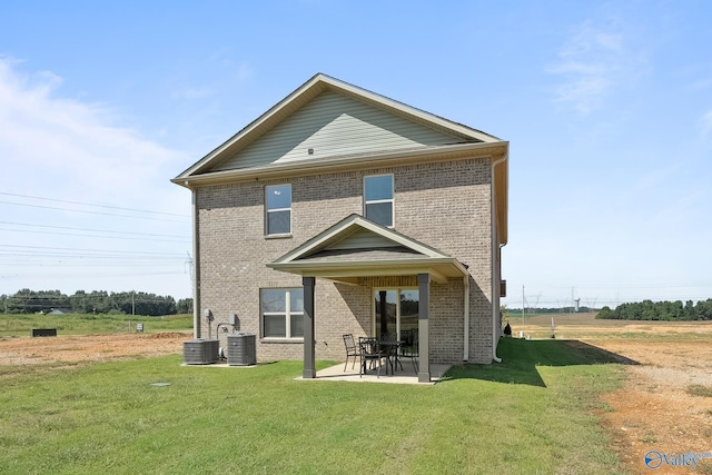 rear view of house with a lawn, central AC unit, and a patio area