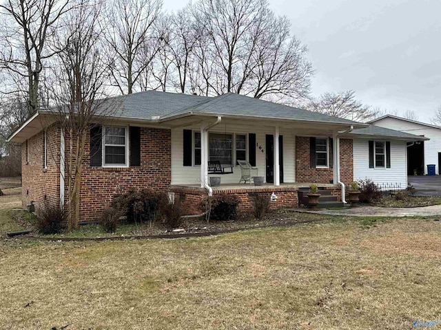 view of front of home with covered porch and a front lawn